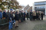 Bloemenhulde en doedelzak aan monument in Zolder