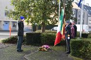 Bloemenhulde en doedelzak aan monument in Zolder