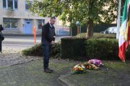 Bloemenhulde en doedelzak aan monument in Zolder